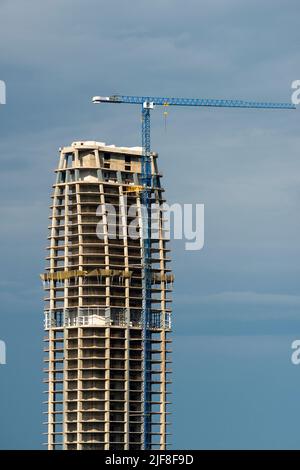 High rise development and under construction site with tower crane Stock Photo