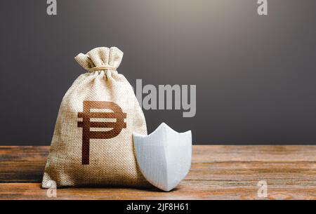 Bag with philippine peso symbol and protection shield. Ensuring the safety of investments in Philippines. Guaranteed protection of retirement savings. Stock Photo