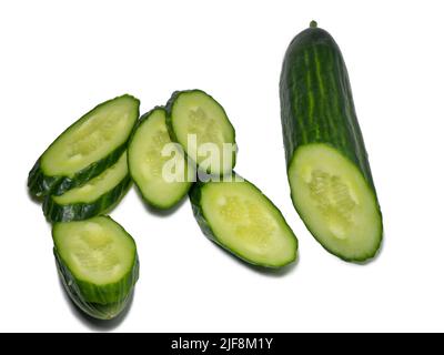 Smooth medium-sized cucumber on a white background. Cucumber slices, isolate. Sliced ​​vegetable. Vegetable isolate. Stock Photo