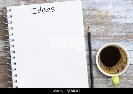 Ideas written on a blank notepad with pencil and cup of coffee with copy space. Concept for your ideas. Stock Photo