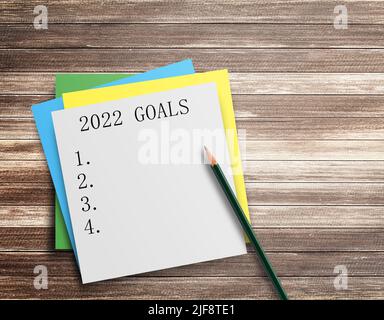 Writing note showing 2022 GOALS on wood table background. top view with copy space.Goals ideas and resolutions for 2022 Stock Photo