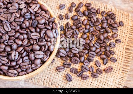 Roasted coffee beans in a wooden bowl on wooden background Stock Photo
