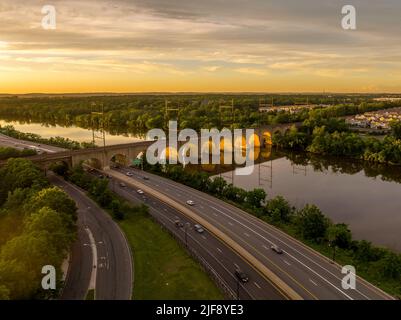 Aerial view of the railroad bridge over the Raritan river in New Brunswick New Jersey as the summer sunset lights up the arches of the bridge Stock Photo