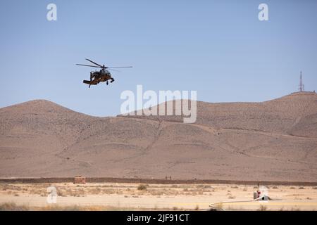 An AH-64D Apache helicopter with Utah National Guard 's 1st Attack Reconnaissance Battalion, 211th Aviation Regiment, Utah Army National Guard descends for landing in Guelmim, Morocco, June 27, 2022, as part of exercise African Lion. The 2022 training exercise marks the first time Apache helicopters have flown, supported, and fired rounds in Morocco. African Lion 2022 is U.S. Africa Command's largest, premier, joint, annual exercise hosted by Morocco, Ghana, Senegal and Tunisia, June 6 - 30. More than 7,500 participants from 28 nations and NATO train together with a focus on enhancing readines Stock Photo