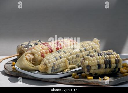Fresh waxy corn or Sweet glutinous corn and Corn kernels on White background. Tropical whole grain food, Copy space, Selective focus. Stock Photo