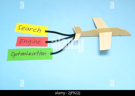 Keyword and Search Engine Optimization or SEO importance and key for success concept in business marketing. Airplane model carrying paper banner. Stock Photo