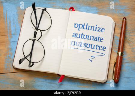 optimize, automate, outsource - business concept, handwriting in a notebook Stock Photo