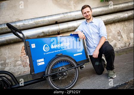 Berlin, Germany. 10th June, 2022. Matti Schurr, CEO and Co-Founder of Avocargo, kneels next to one of his company's cargo bikes outside Motionlab Berlin. Berlin-based startup Avocargo offers e-load bikes in Berlin and plans to expand its services to other cities this year. (to dpa 'Mission 'make mainstream' - cities want to establish cargo bikes') Credit: Fabian Sommer/dpa/Alamy Live News Stock Photo