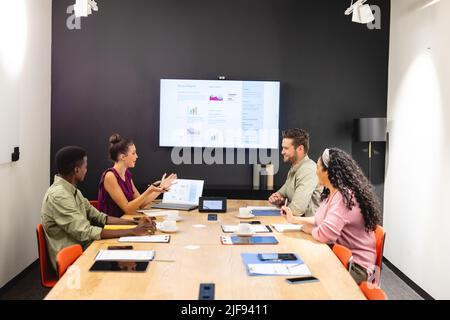 Multiracial businessmen and businesswomen discussing during meeting in board room Stock Photo