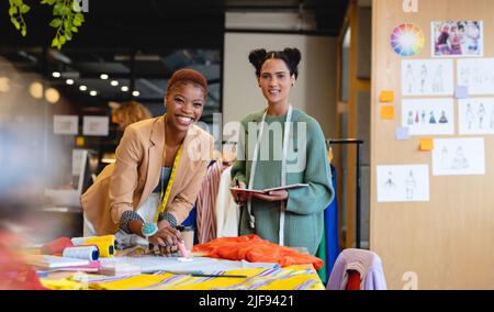 Portrait of smiling multiracial young female fashion designers working in office Stock Photo