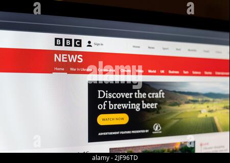 BBC News webpage on PC screen. BBC News is operational division responsible for news gathering and broadcasting. Division is world's largest broadcast Stock Photo