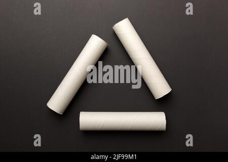 Empty toilet paper roll on colored background. Recyclable paper tube with metal plug end made of kraft paper or cardboard in the form of a recycling s Stock Photo