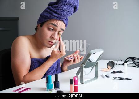 Young drag queen man applying eyeshadow. Stock Photo