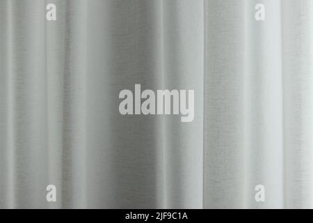 Linen curtains make folds. Linen fabrics in the interior. Soft textile background. Stock Photo
