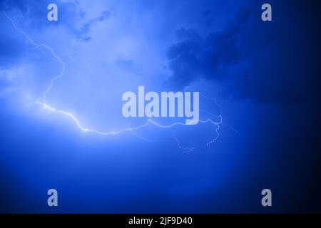 Dark cloudy sky with blue lightning Stock Photo