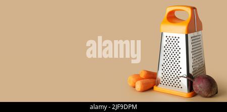Metal grater, carrots and beetroot on color background with space for text Stock Photo