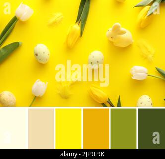 Painted Easter eggs, tulip flowers and feathers on yellow background. Different color patterns Stock Photo