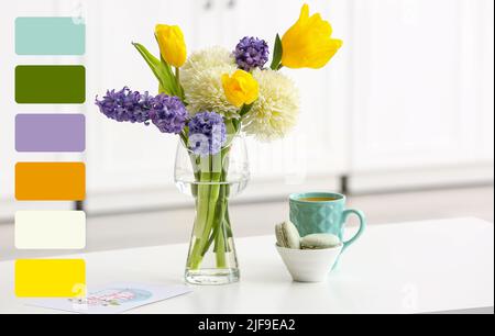 Vase with beautiful flowers, tasty macarons and cup of coffee on dining table in kitchen. Different color patterns Stock Photo