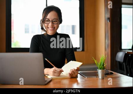 Professional young Asian female office worker or female manager with eyeglasses having an online meeting with her coworker. Stock Photo