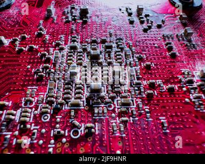 Close-up of transistors and chips on the red circuit board Stock Photo