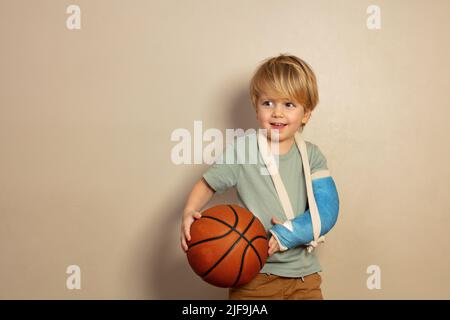 Smiling little blond boy with basketball ball Stock Photo