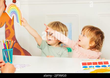 Little kids point to the rainbow card at development class Stock Photo