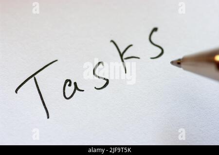 Close up image of handwritten word TASKS. Stock Photo