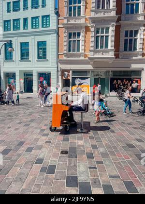 A vertical shot of a man playing the piano on the street of Rostock in Germany Stock Photo