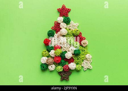 Christmas tree made from colored handmade ball decoration on colored background, view from above. New Year minimal concept with copy space. Stock Photo