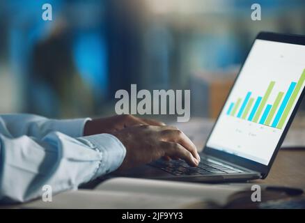 Closeup hands of african man working on a laptop. African american business man using a computer while working late at night in his office. Putting in Stock Photo