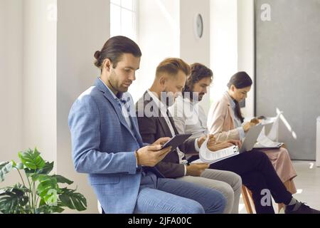 Group of busy people sitting in line in office and waiting for business appointment Stock Photo