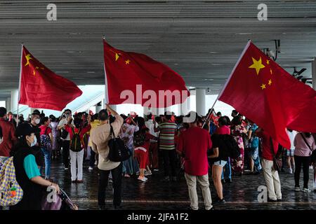 Hong Kong, China. 1st July, 2022. China supporters hold People's Republic of China flags gather at the Star Ferry pier and celebrate the 25th anniversary Hong Kong handover to China. The Chinese president Xi Jinping is visiting the city to mark the 25th Anniversary of the establishment of the Hong Kong Special Administrative Region (HKSAR) of the People's Republic of China. (Credit Image: © Keith Tsuji/ZUMA Press Wire) Stock Photo