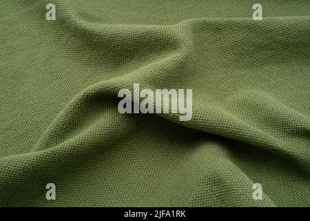 Textured fabric background. An olive green coloured ruched up linen. Stock Photo