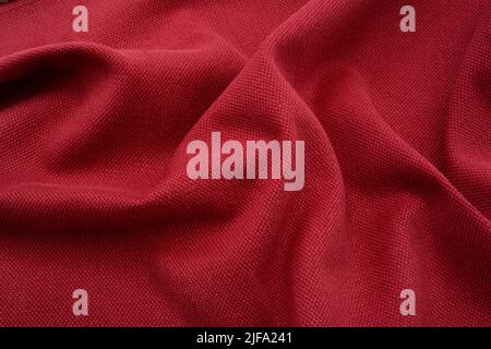 Textured fabric background. A red ruched linen fabric. Stock Photo