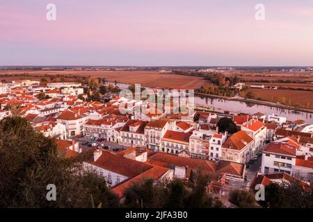 Beautiful view over the center of the village of Coruche in Portugal, at sunset, with the river Sorraia and the agricultural fields in the background. Stock Photo