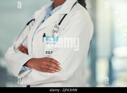 Body of doctor in the hospital cropped. Confident doctor arms crossed in the hospital. African american doctor wearing a badge in the clinic. Closeup Stock Photo