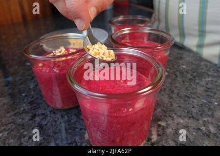 Southern German cuisine, preparation walnut cake with beetroot, beetroot-carrot nut cake in a jar, dough, sprinkle mass with roasted nuts, preserving Stock Photo