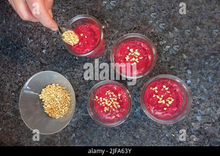 Southern German cuisine, preparation walnut cake with beetroot, beetroot-carrot nut cake in a jar, dough, sprinkle mass with roasted nuts, preserving Stock Photo