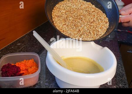 Southern German cuisine, preparation walnut cake with beetroot, beetroot-carrot nut cake, add roasted nuts to batter, walnuts chopped, mixing bowl Stock Photo