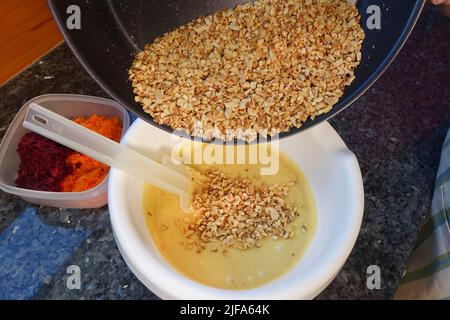 Southern German cuisine, preparation walnut cake with beetroot, beetroot-carrot nut cake, add roasted nuts to batter, walnuts chopped, mixing bowl Stock Photo