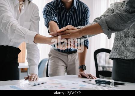 Close up happy diverse business people putting hands together, showing support and unity. Multiracial colleagues involved in team building activity Stock Photo