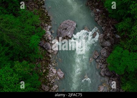 Drone aerial view of wild river Enns in cloudy weather in Gesause National Park near town of Admont in centre Austria. Visible green river banks, rapi Stock Photo