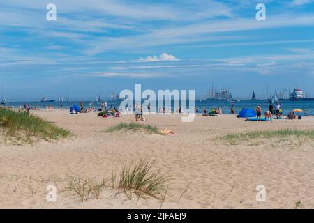 Falkenstein beach, spectators of the windjammer parade, gaff schooner, leisure, bathing, parasol, dune grass, horizon, summer, blue sky, Kieler Woche Stock Photo