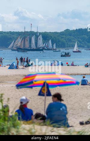 Falkenstein beach, spectators of the windjammer parade, three-mast gaff schooner, leisure, bathing, sunshade, forest, windbreak, summer, blue sky Stock Photo