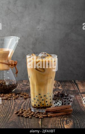 Bubble tea with coffee and chocolate in glass cup on dark background. Stock Photo