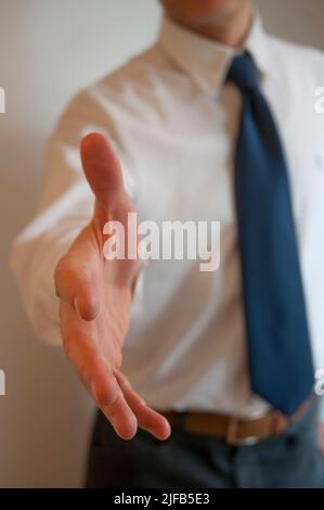 Man extending his open hand, offering handshake. Stock Photo