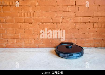 Robotic vacuum cleaner charging on dock station Stock Photo