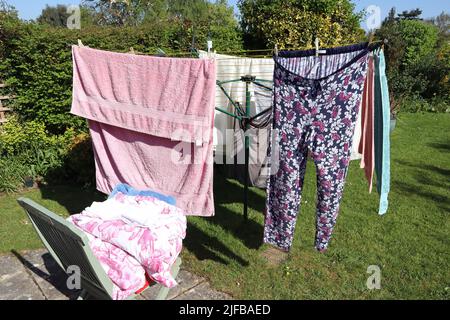 Clothes hanging from a rotary airer drying in the sun Stock Photo