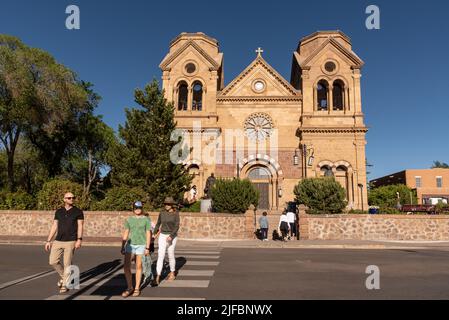 A family in the crosswalk in front of The Cathedral Basilica of St. Francis of Assisi in Santa Fe, New Mexico, United States. Stock Photo