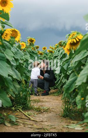 Mother with baby son in sunflower field Stock Photo - Alamy